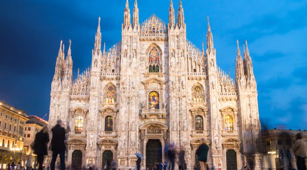 Milan Cathedral - Duomo di Milano - is the gothic cathedral church of Milan, Italy. Shot in the dusk from the square ful of people.